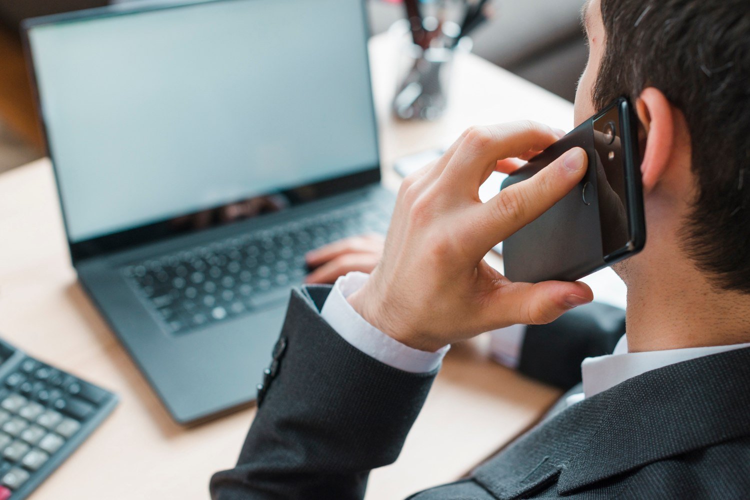 Office desktop with laptop and a business man
