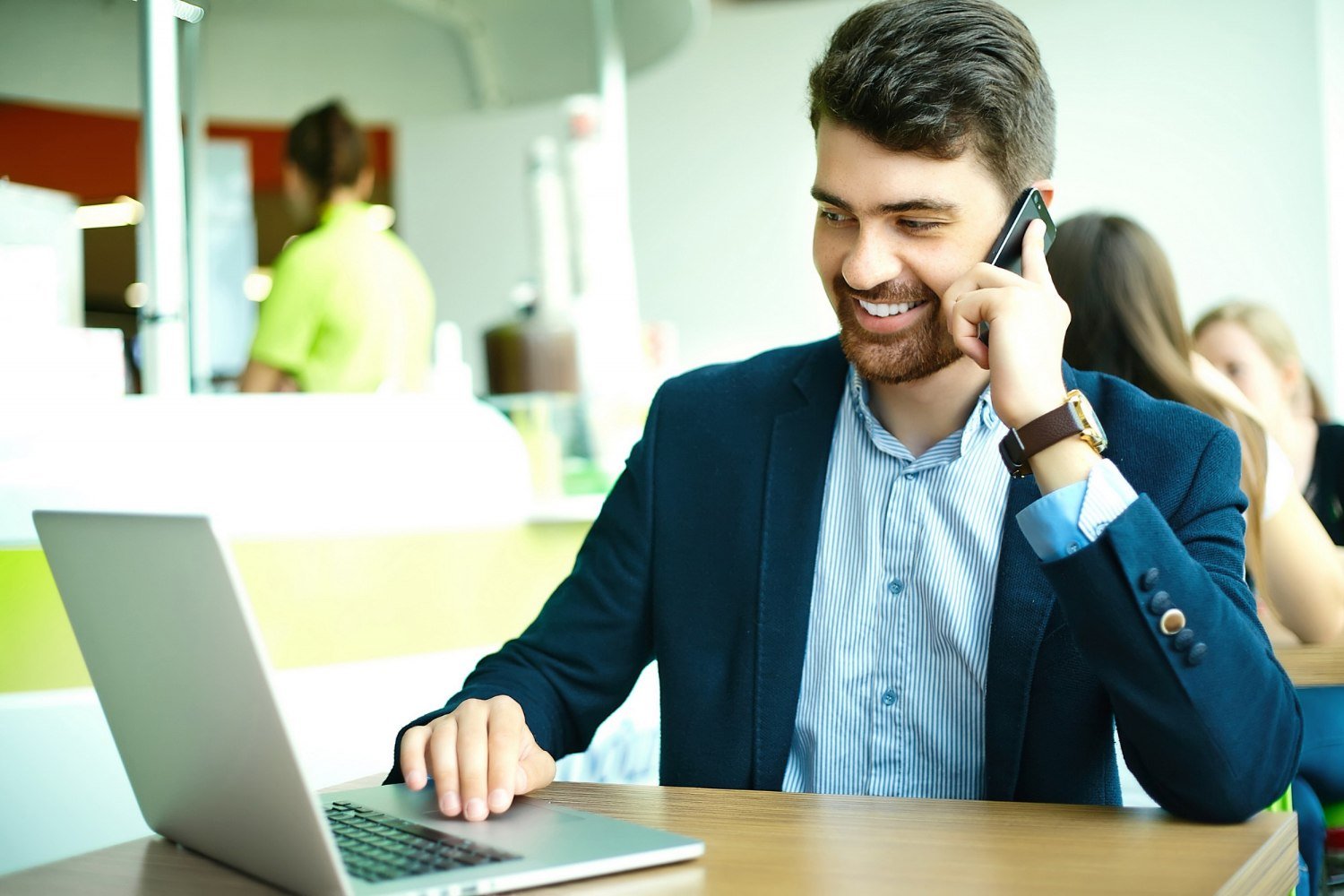 Young fashion smiling hipster man in the city cafe during lunch time with notebook in suit speaking on phone Young fashion smiling hipster man in the city cafe during lunch time with notebook in suit speaking on phone
